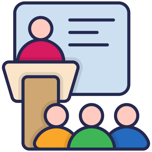 Eine Person steht energisch am Rednerpult vor einem Publikum.